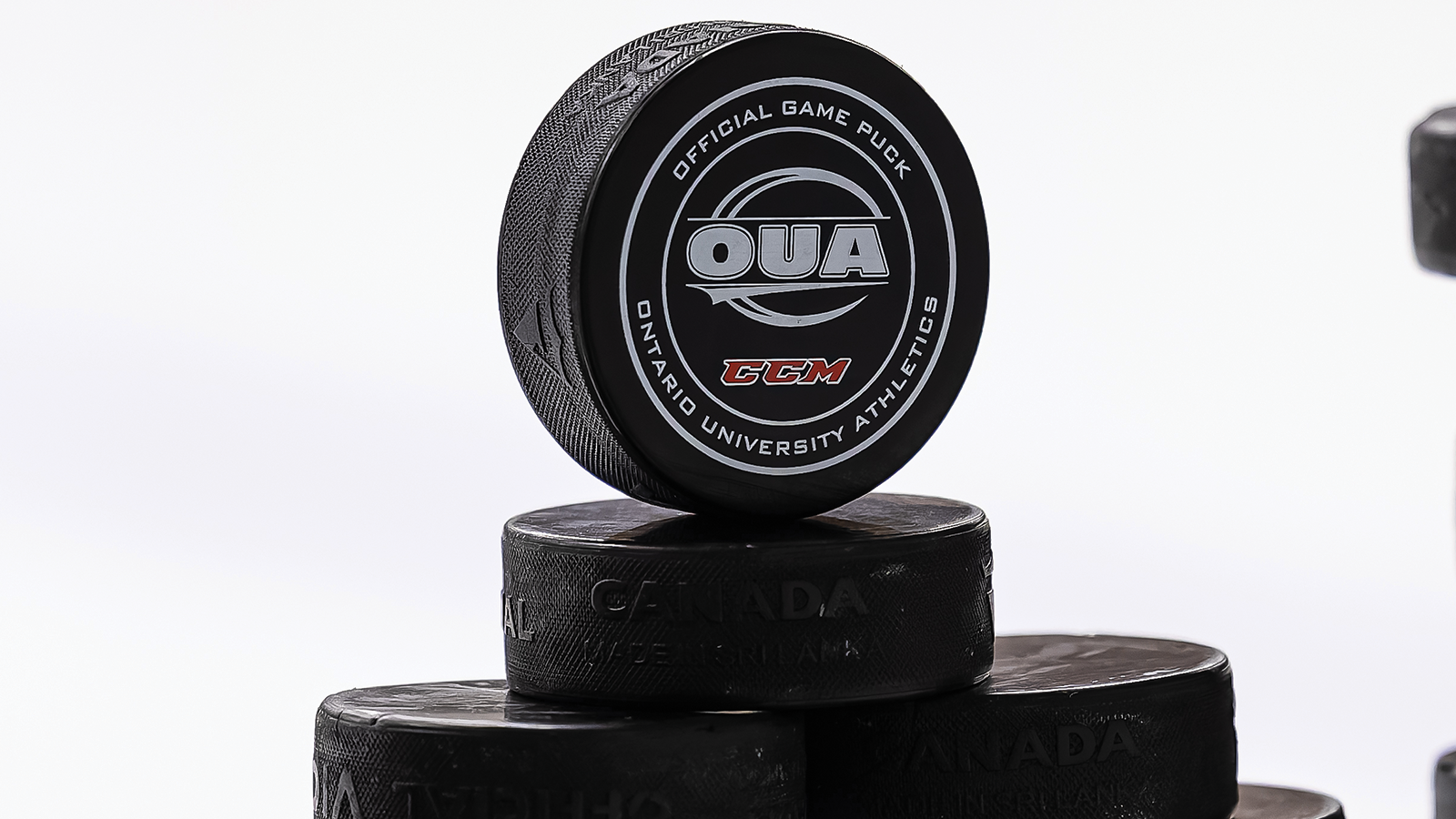 Photo of a stack of OUA pucks with the OUA logo 