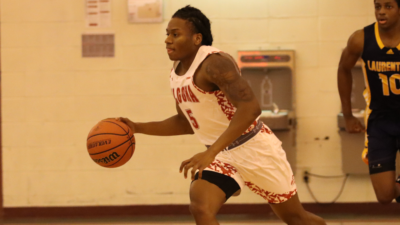 Algoma men's basketball player dribbling the basketball