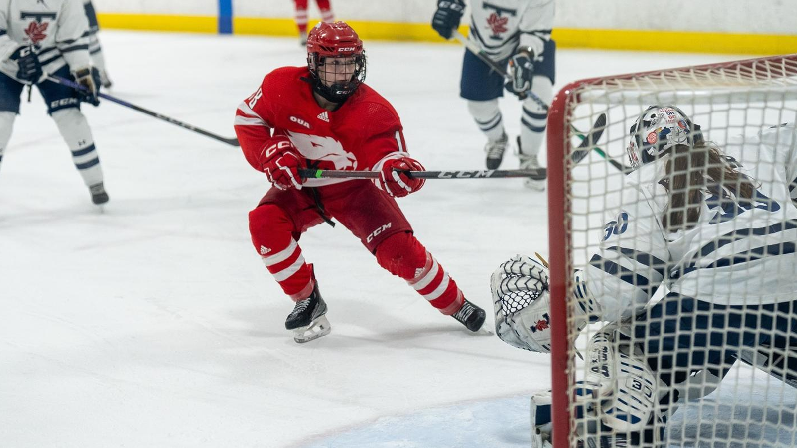 York women's hockey player skating in front of the next having just taken a shot on the Toronto goaltender