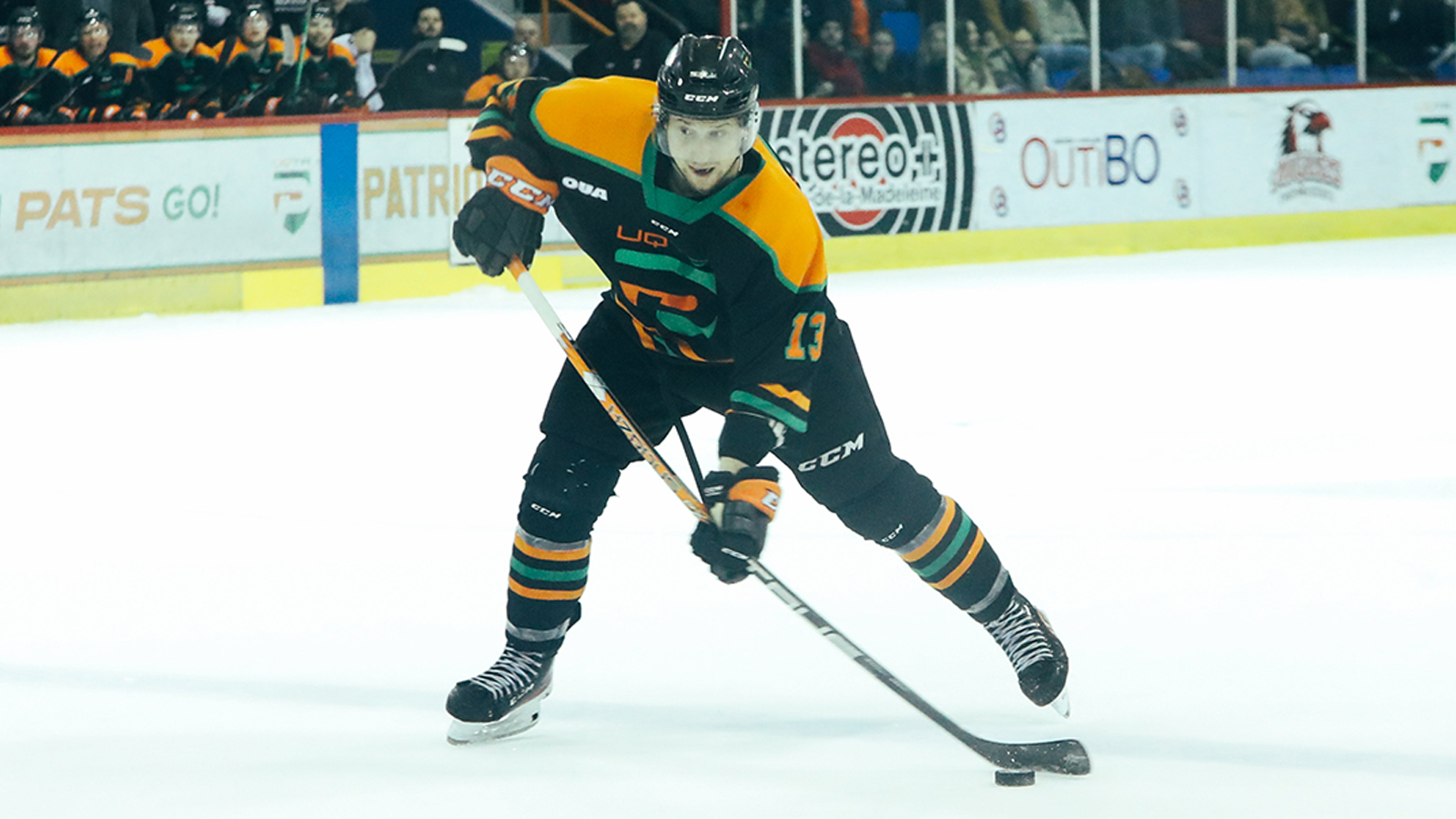 UQTR men's hockey player with the puck on his stick as he prepares to shoot it during a game