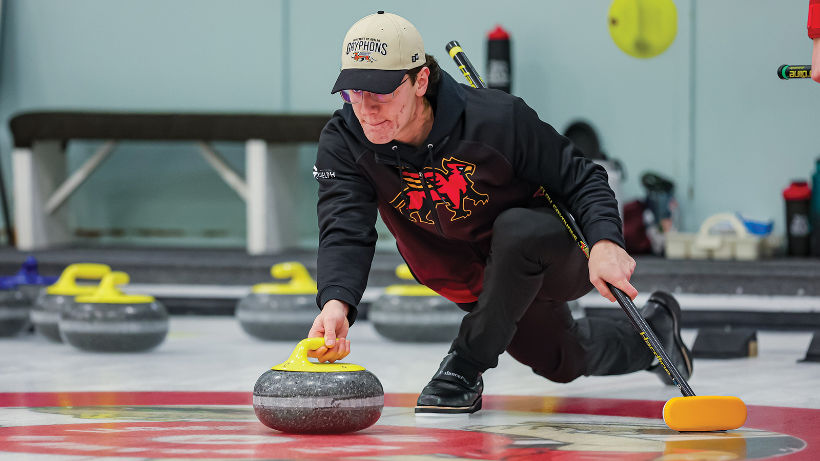 Action photo of a Guelph Gryphons men's curler throwing the curling stone