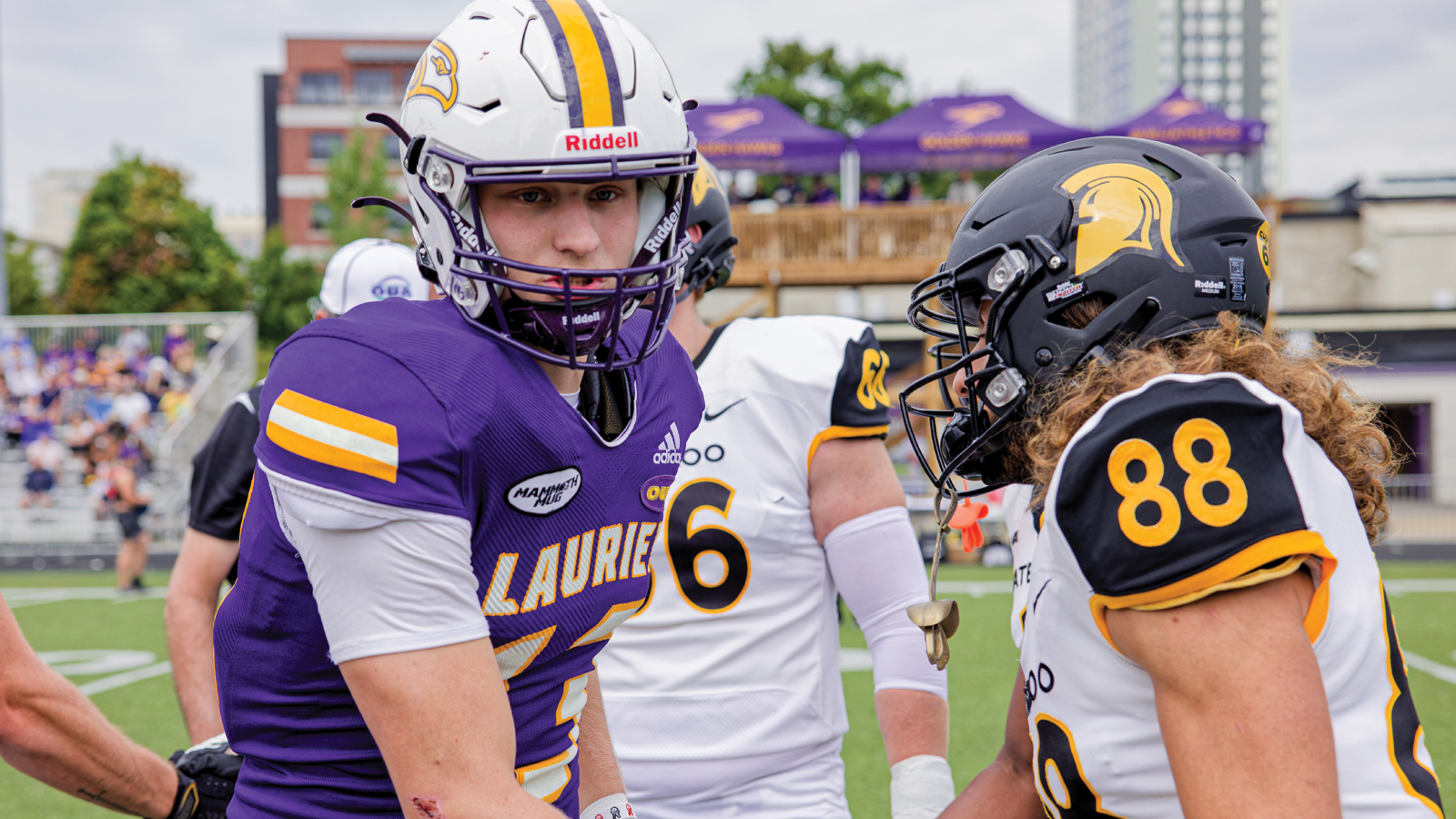 Laurier football player and Waterloo football player shaking hands on the field after the game