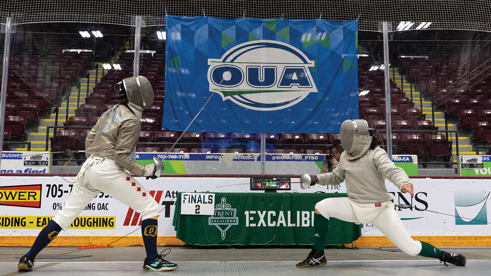 Action photo of two women's fencers fencing, one from Queen's and one from Trent 