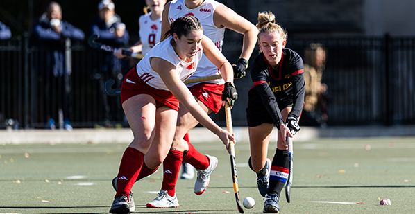 Action photo of a York field hockey player and a Guelph field hockey player 