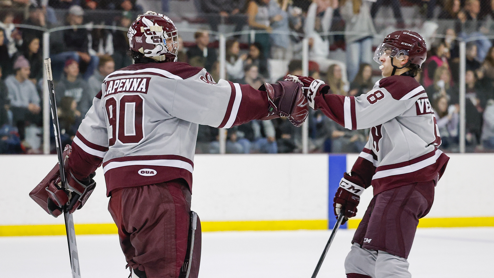 Ottawa Gee-Gees goaltender and player fist bumping on the ice in celebration of a win
