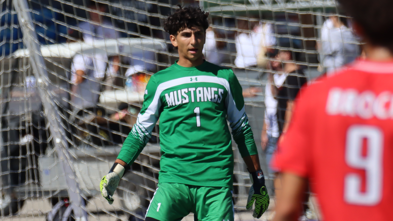 Western men's soccer goalkeeper looking out toward the field from his net