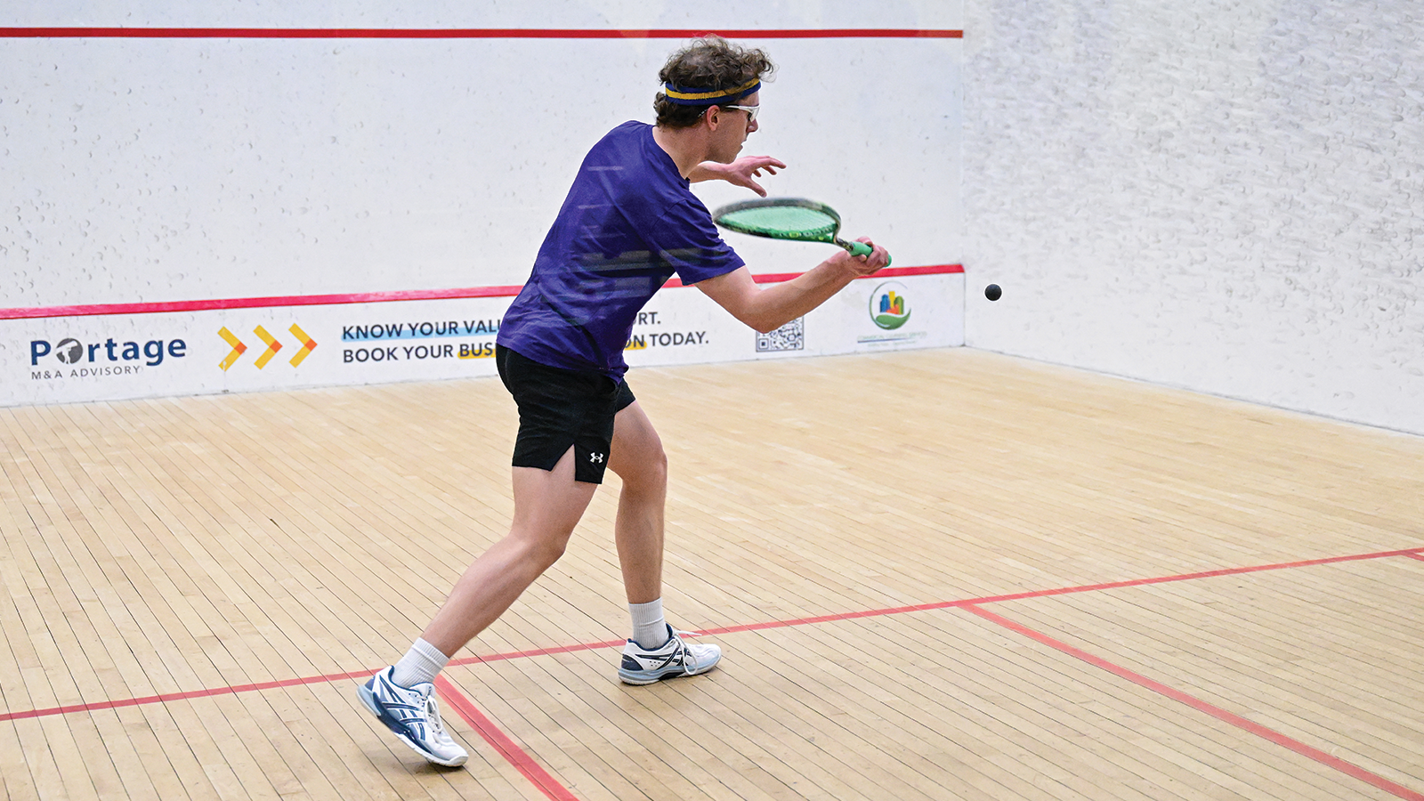 Action photo of a Western Mustangs men's squash player 